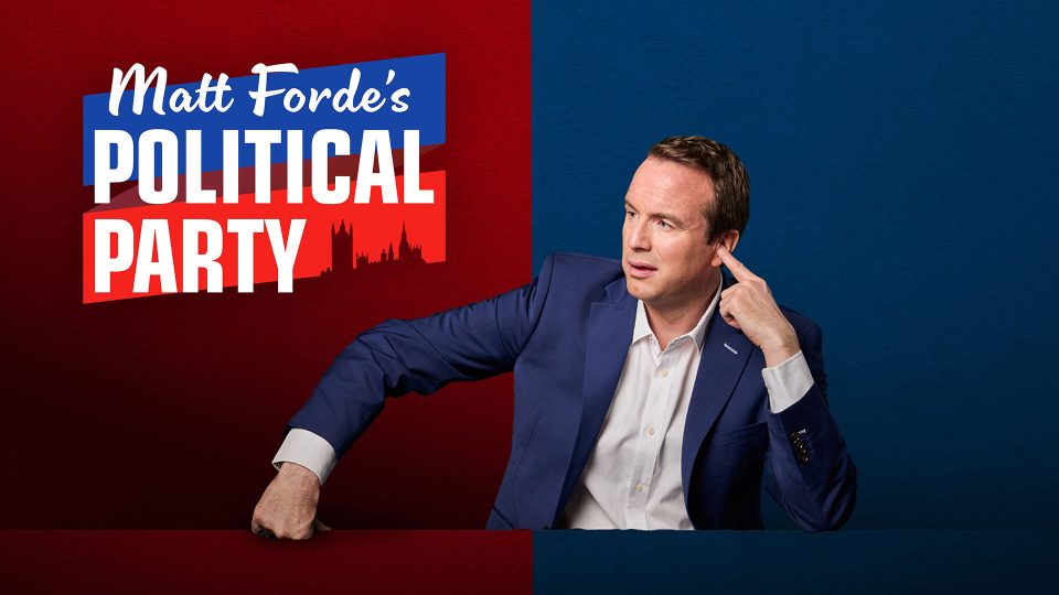 Matt Forde's Political Party 13 Matt Forde gestures thoughtfully, wearing a blue suit against a red and blue background.