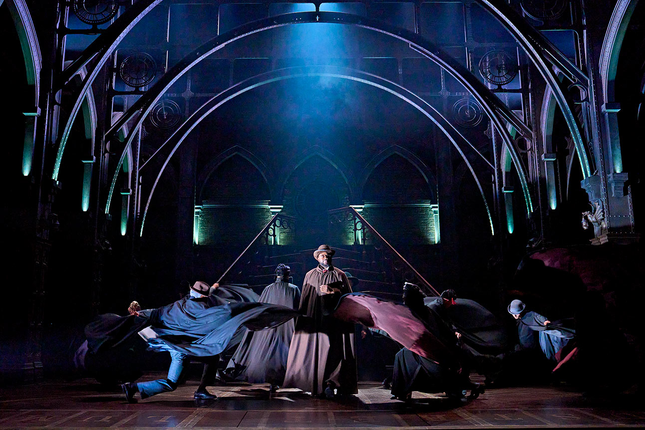 Stage performance of "Harry Potter and the Cursed Child" with actors in dynamic poses under blue lighting.