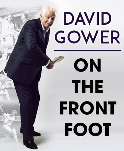 David Gower in a suit, holding a cricket bat with a blurred cricket scene behind.