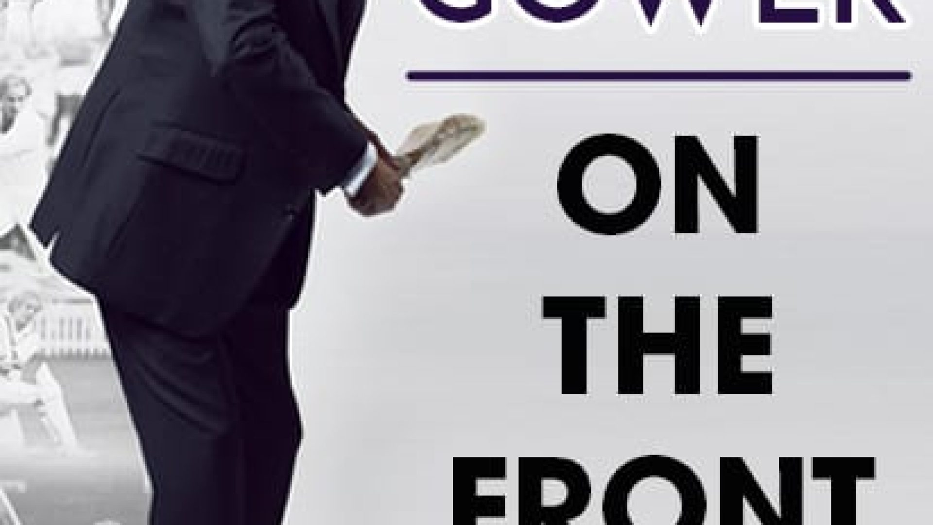 David Gower poses in a dark suit, holding a cricket bat with a faded sports backdrop.