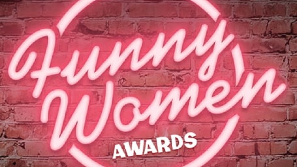 Neon pink sign reading 'Funny Women Awards' against a textured brick wall.