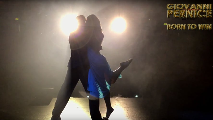 Silhouetted dancers on stage with dramatic lighting, promoting 'Giovanni Pernice: Born to Win'.