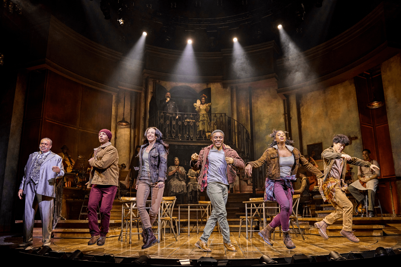 The ensemble of Hadestown dance in a line energetically