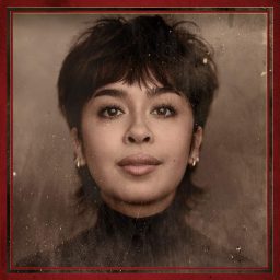 Jasmine Triadi swings mid-air on stage, wearing a red dress against a dark theatrical background.