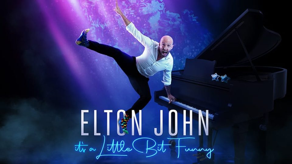 A man in a white shirt leaps beside a grand piano, with purple lighting.