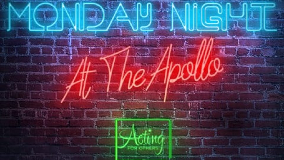 Neon sign reading 'MONDAY NIGHT At The Apollo' against a dark brick background.
