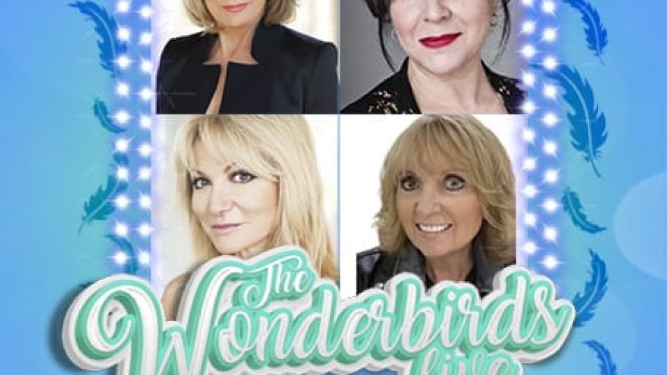 Four women with glamorous hairstyles and outfits, surrounded by decorative lights.