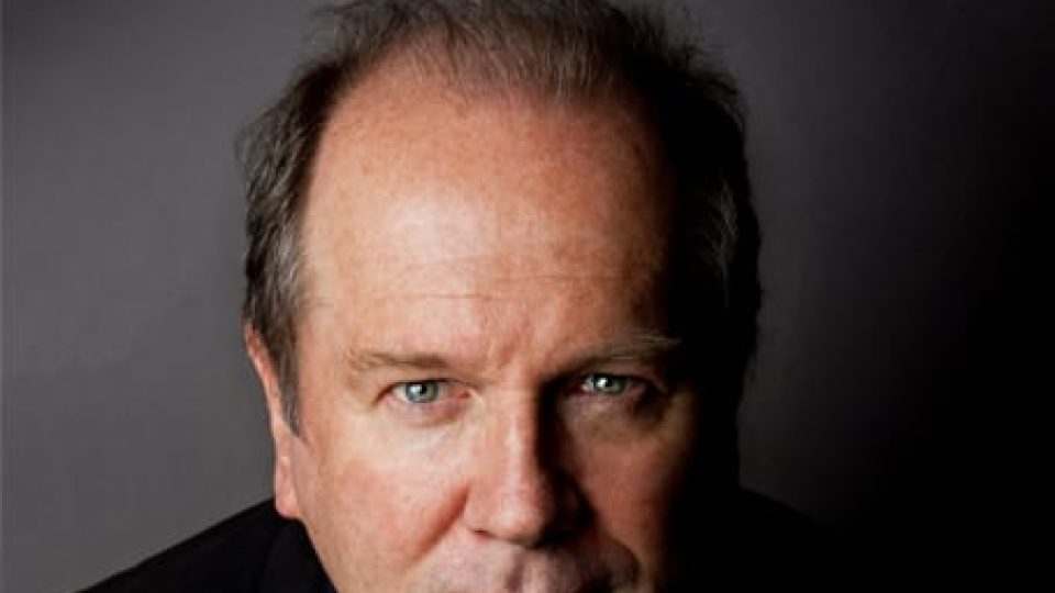 A book cover featuring a man with blue eyes and grey hair against a dark background.