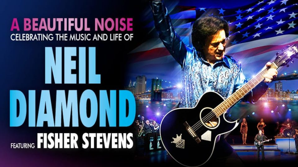 A performer in a blue shirt plays guitar with a vibrant city skyline behind.