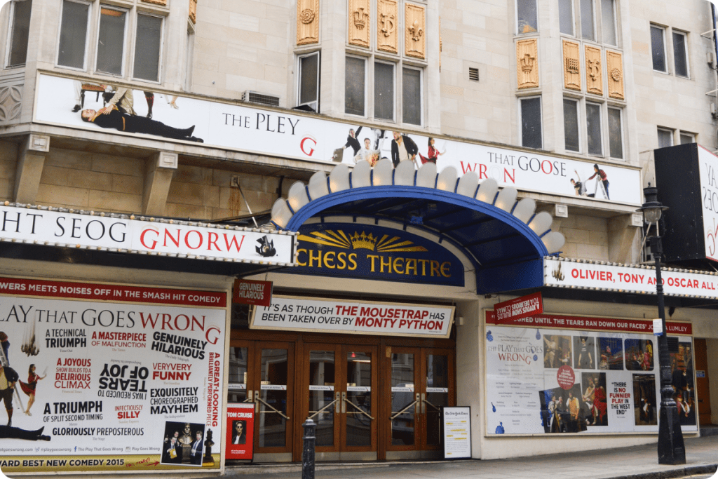 Duchess Theatre entrance featuring blue awning and promotional banners for "The Play That Goes Wrong.