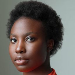 Choolwe Laina Muntanga looks directly at the camera with a neutral expression against a plain grey background.