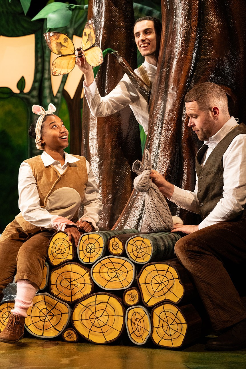 Two actors in costume perform a scene from "The Gruffalo" on a stage with tree backdrop.