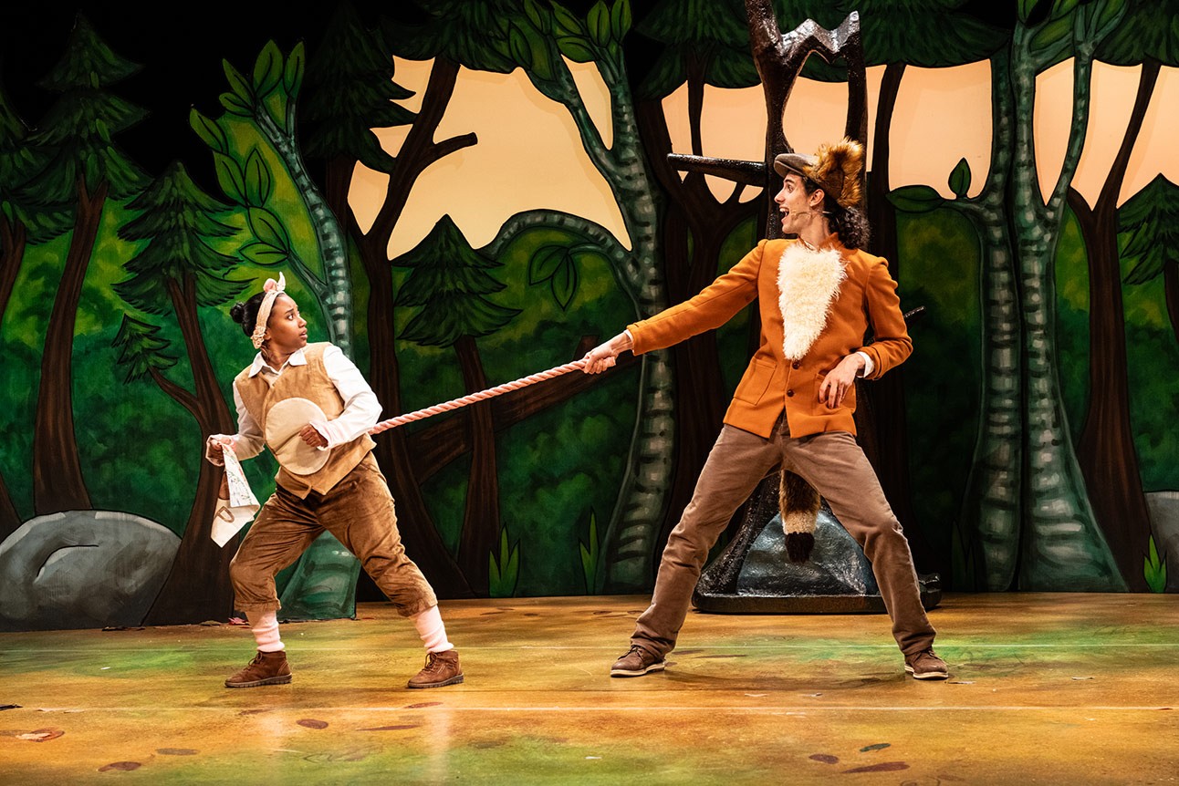 Rianna Kellman and Jordan Cottle perform in animal costumes on a forest-themed stage.