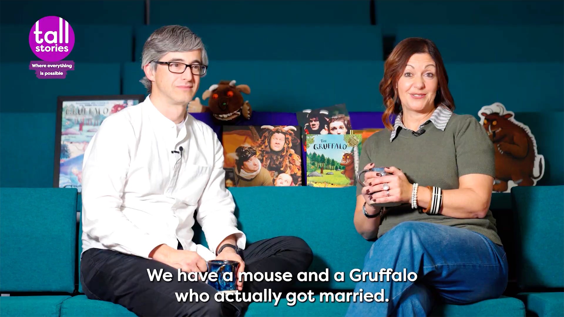 Toby Mitchell and Olivia Jacobs seated, discussing The Gruffalo’s 25-year stage history against a dark backdrop.