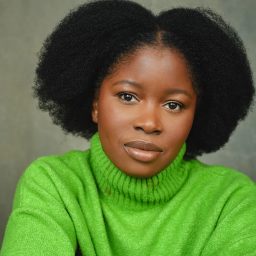 Tsemaye Bob Egbe stands smiling against a plain background, wearing a dark jacket and light shirt.