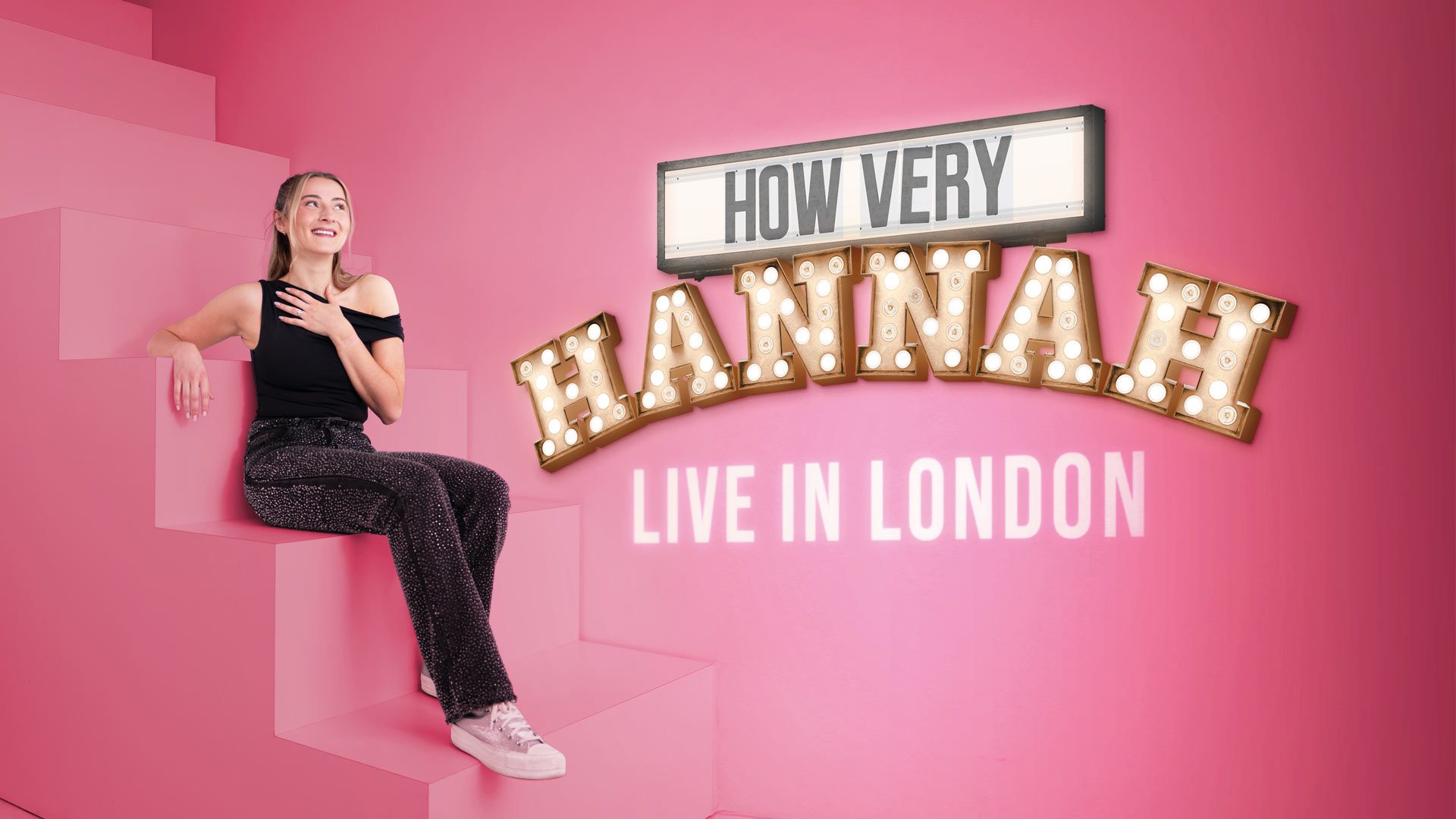 Hannah Lowther in black outfit sits on pink steps; text reads "How Very Hannah Live in London.