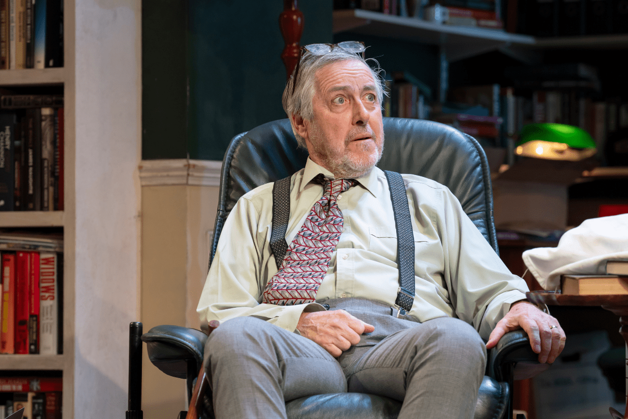 Jim Hacker sits in his desk chair looking shocked