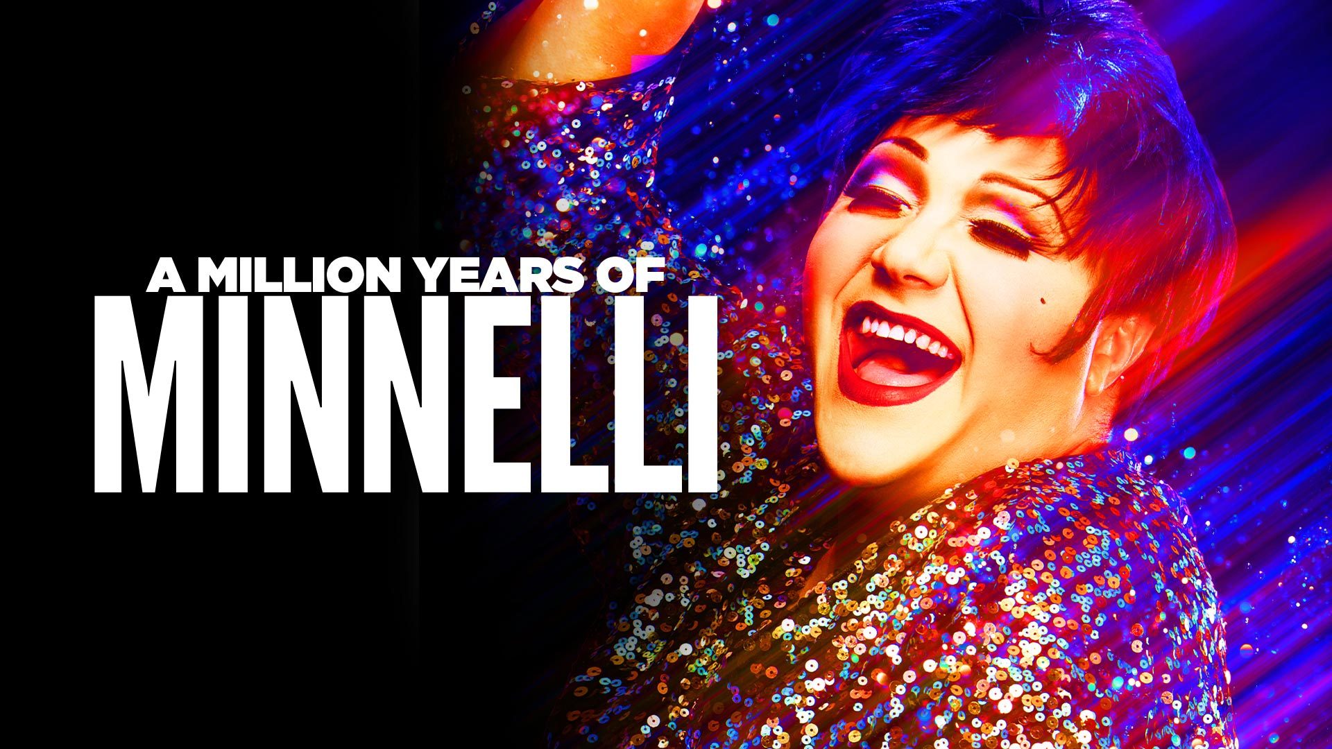 Trevor Ashley wearing a sequined dress, with a spotlight and dark background.