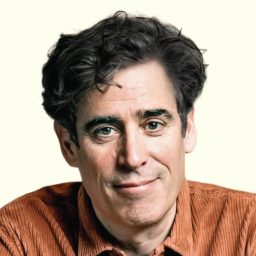 Stephen Mangan smiling against a pale background