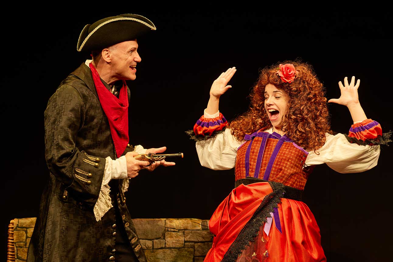 Two actors in period costumes, one with a tricorne hat and pistol, the other surprised.