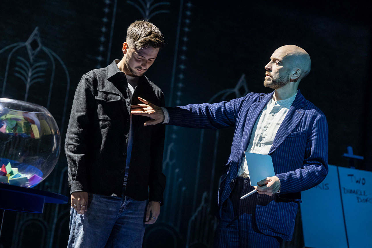 Derren Brown interacting with an audience member who has their eyes closed.