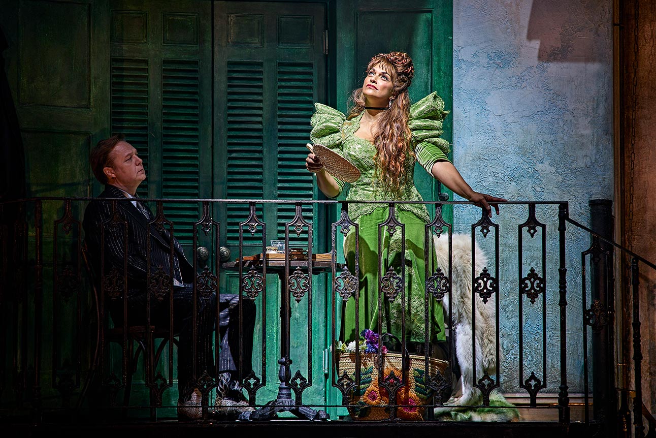 Shaun Dooley and Danielle de Niese perform on stage in "Hadestown," with ornate balcony backdrop.